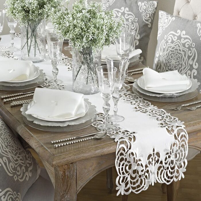 Add elegance to your dining table with this table runner by Saro Lifestyle. This Cutwork Design runner features an eye-catching cutout border that dresses up your table for special occasions or everyday entertaining. The 100-percent polyester material is machine-washable for easy care.